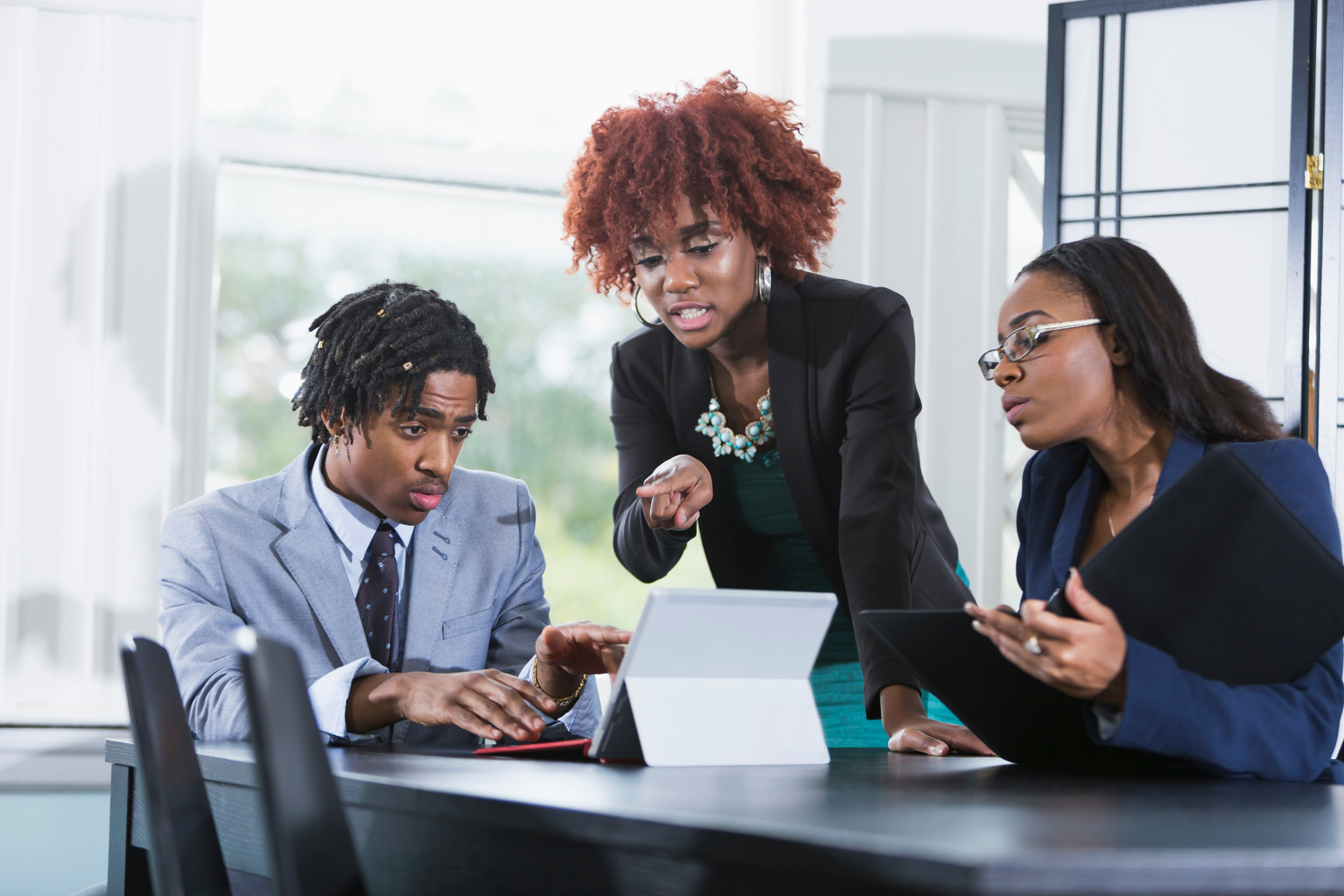 Team of three young black businesspeople working